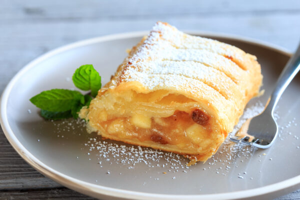 Homemade appel strudel filled flavored with brown sugar, cinnamo, raisins and sliced